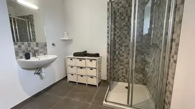 a bathroom with a shower and a sink at Modern apartment large terrace and beautiful view in Quarante