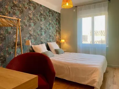 a bedroom with a large bed and a window at La Pause Carcassonnaise in Carcassonne
