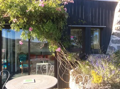 a patio with a table and chairs and flowers at Domaine Castelsec in Roquefort-des-Corbières