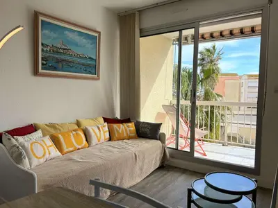 a living room with a couch and a large window at Appartement cosy proche plage & commerces GN450-A205 in Gruissan