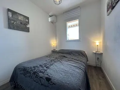 a bedroom with a bed and a window with two lights at Appartement cosy proche plage & commerces GN450-A205 in Gruissan