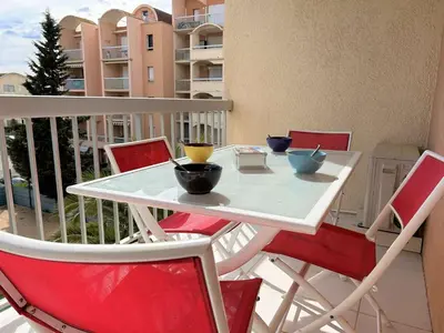 a white table and chairs on a balcony at Appartement cosy proche plage & commerces GN450-A205 in Gruissan