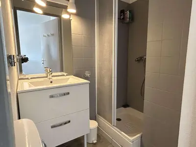 a white bathroom with a sink and a shower at Appartement cosy proche plage & commerces GN450-A205 in Gruissan
