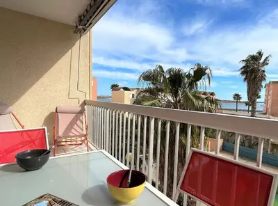 a balcony with a table and chairs and a view of the ocean at Appartement cosy proche plage & commerces GN450-A205 in Gruissan