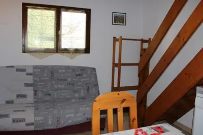 a bedroom with a bed and a wooden chair at Pavillon Cosy 3 pièces avec véranda et parking GN520-048 in Gruissan