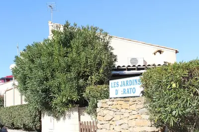 a street sign in front of a house with trees at Pavillon Cosy 3 pièces avec véranda et parking GN520-048 in Gruissan