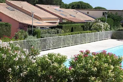 a white fence around a swimming pool with houses at Appartement Studio Cabine - Gruissan GN020-211 in Gruissan