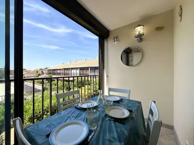 a dining room table with a view of a balcony at Appartement Studio Cabine - Gruissan GN020-211 in Gruissan