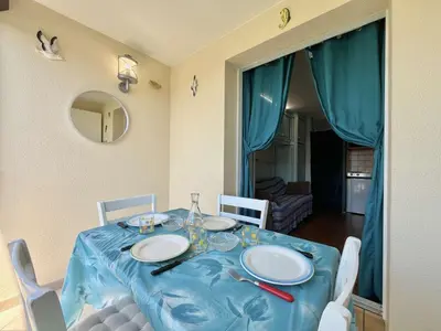 a table with a blue table cloth and white plates on it at Appartement Studio Cabine - Gruissan GN020-211 in Gruissan