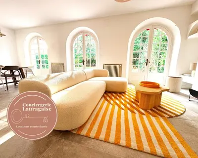 a living room with a white couch and a striped rug at Maison Agane - accès canal du midi, piscine chauffée in Pexiora