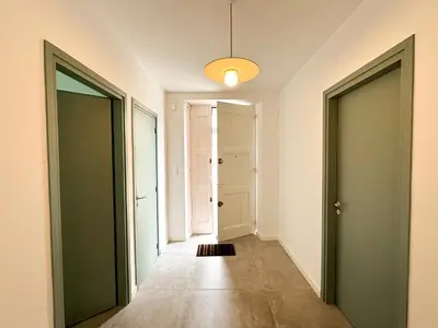 an empty hallway with two doors and a light fixture at Maison Agane - accès canal du midi, piscine chauffée in Pexiora