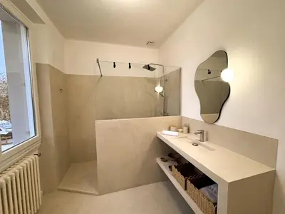 a bathroom with a sink and a shower and a mirror at Maison Agane - accès canal du midi, piscine chauffée in Pexiora