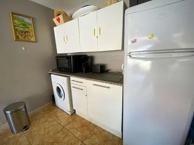 a kitchen with a white refrigerator and a washing machine at Maison climatisée front de plage du Grazel GA080-086 in Gruissan
