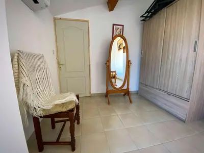 a room with a mirror and a chair and a door at Maison climatisée front de plage du Grazel GA080-086 in Gruissan