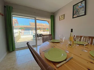 a dining room table with plates and wine glasses at Maison climatisée front de plage du Grazel GA080-086 in Gruissan
