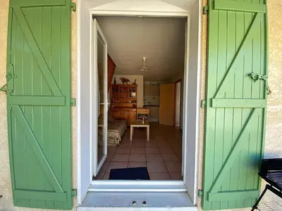 an open doorway to a room with green doors at Maison climatisée front de plage du Grazel GA080-086 in Gruissan