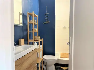 a bathroom with a toilet and a blue wall at Appartement 2 pièces vue mer Port La Nouvelle PN400-034 in Port-la-Nouvelle