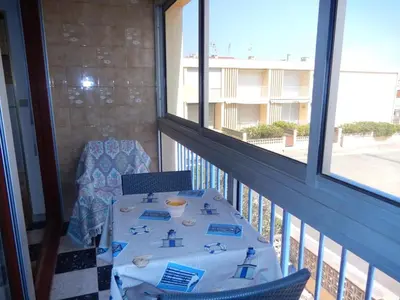 a table and chairs on a balcony with a view of a building at Appartement 3 pièces PORT LA NOUVELLE PN540-008 in Port-la-Nouvelle