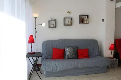 a blue couch with red pillows in a living room at Appartement studio PORT LA NOUVELLE PN590-014 in Port-la-Nouvelle