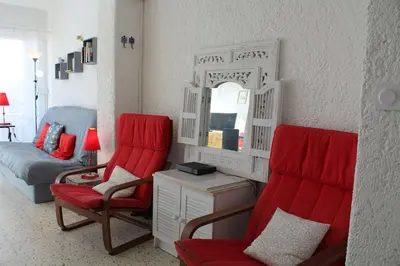 a living room with red chairs and a mirror at Appartement studio PORT LA NOUVELLE PN590-014 in Port-la-Nouvelle