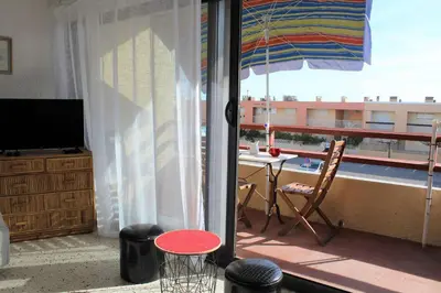 a room with a balcony with a table and an umbrella at Appartement studio PORT LA NOUVELLE PN590-014 in Port-la-Nouvelle