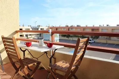 a table and chairs on a balcony with a view at Appartement studio PORT LA NOUVELLE PN590-014 in Port-la-Nouvelle
