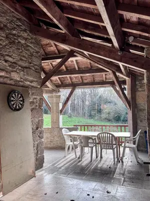 a patio with a table and chairs in a building at Maison au coeur de la forêt dans le Sidobre - GR36 in Lacrouzette