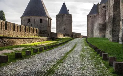 a cobblestone road in a castle with turrets at DOMITYS - Carmina in Carcassonne
