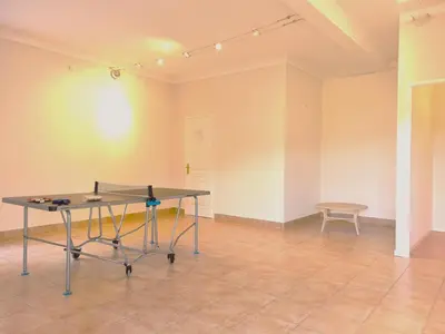 a ping pong table in an empty room with a bench at Belle Bize in Bize-Minervois