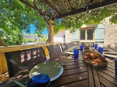 a wooden table with a plate of food on it at Belle Bize in Bize-Minervois