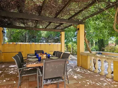 a table and chairs on a patio with a pergola at Belle Bize in Bize-Minervois