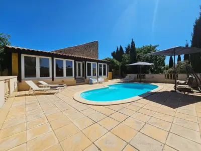 a patio with a pool and chairs and an umbrella at Belle Bize in Bize-Minervois