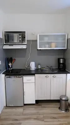 a kitchen with a sink and a microwave at RDC cosy en centre ville in Narbonne