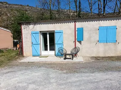a bench in front of a building with blue doors at LA FALAISE - Quiet T3 apartment with private parking in Caucalières