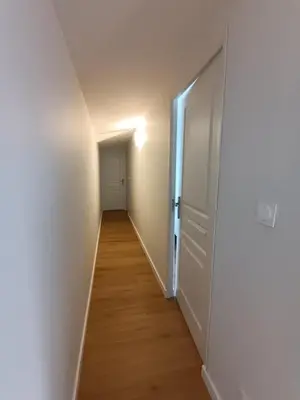 an empty hallway with a white door and a wooden floor at LA FALAISE - Quiet T3 apartment with private parking in Caucalières
