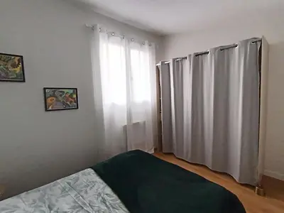 a bedroom with a bed and a window with curtains at LA FALAISE - Quiet T3 apartment with private parking in Caucalières