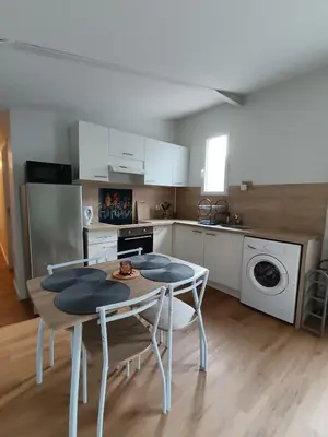 a kitchen with a table and chairs in a room at LA FALAISE - Quiet T3 apartment with private parking in Caucalières