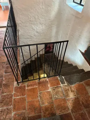 a staircase with a metal railing in a building at Ostal de la Croix Vieussan in Vieussan