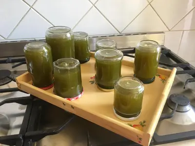 a tray with four jars of green juice on a stove at Château de Villeneuve - Montolieu in Montolieu