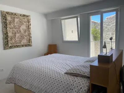 a white bedroom with a bed and a window at La Novèla, Maison de Village Rooftop in Port-la-Nouvelle