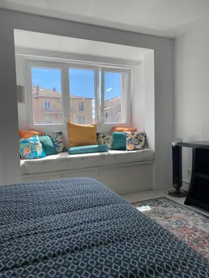 a bedroom with a window seat with pillows at La Novèla, Maison de Village Rooftop in Port-la-Nouvelle