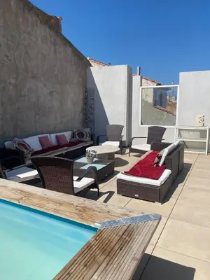 a patio with a couch and chairs and a pool at La Novèla, Maison de Village Rooftop in Port-la-Nouvelle