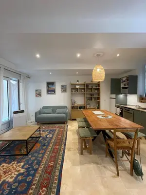a living room with a table and a couch at Appartement RDC avec cour privée - Narbonne Les Halles Centre Historique in Narbonne