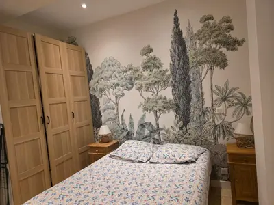 a bedroom with a bed and a mural of trees at Appartement RDC avec cour privée - Narbonne Les Halles Centre Historique in Narbonne