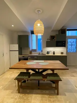 a large kitchen with a wooden table and a dining room at Appartement RDC avec cour privée - Narbonne Les Halles Centre Historique in Narbonne
