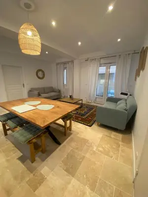 a living room with a wooden table and a couch at Appartement RDC avec cour privée - Narbonne Les Halles Centre Historique in Narbonne