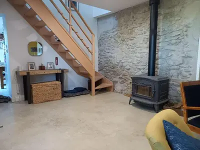 a living room with a stove and a staircase at Domaine Saint Augustin in Rieux-Minervois