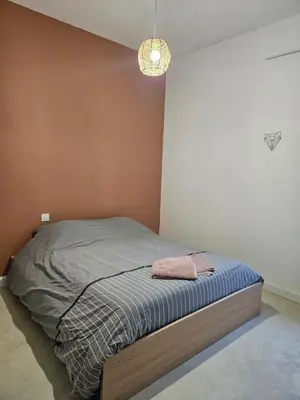a small bed in a bedroom with a light at Domaine Saint Augustin in Rieux-Minervois
