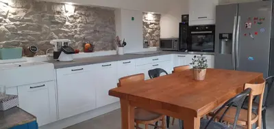 a kitchen with a wooden table and white cabinets at Domaine Saint Augustin in Rieux-Minervois