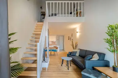 a living room with a staircase and a couch at L'Hippocrate Duplex à deux pas des Halles in Narbonne